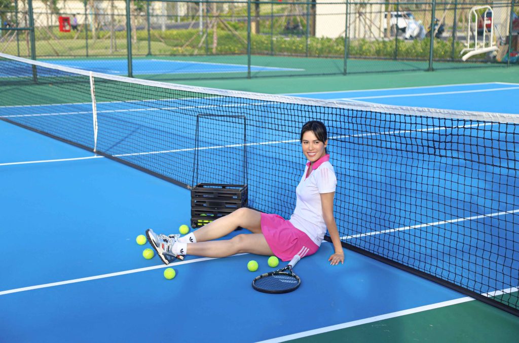 A guest sitting on the ground in the tennis court
