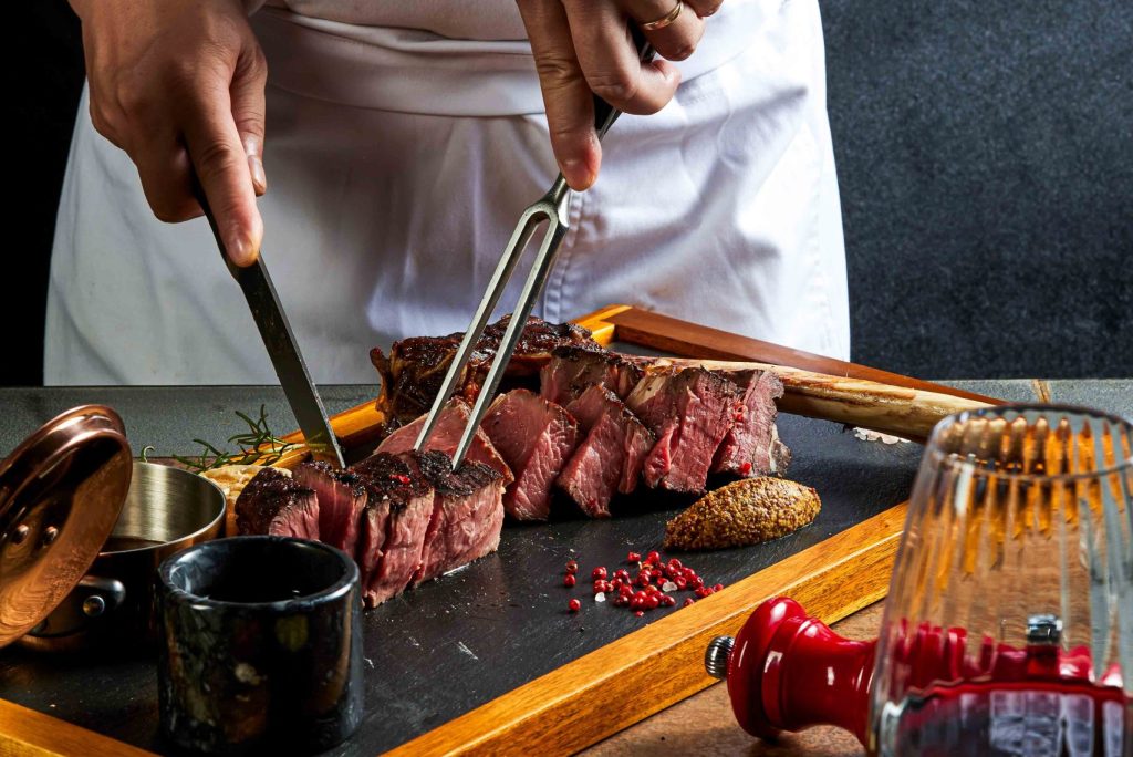 A chef slicing up steak at Fusion Resort